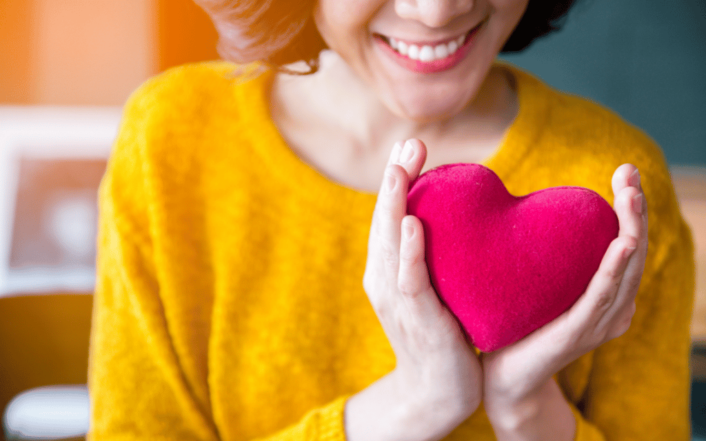 mulher feliz segurando almofada em formato de coração